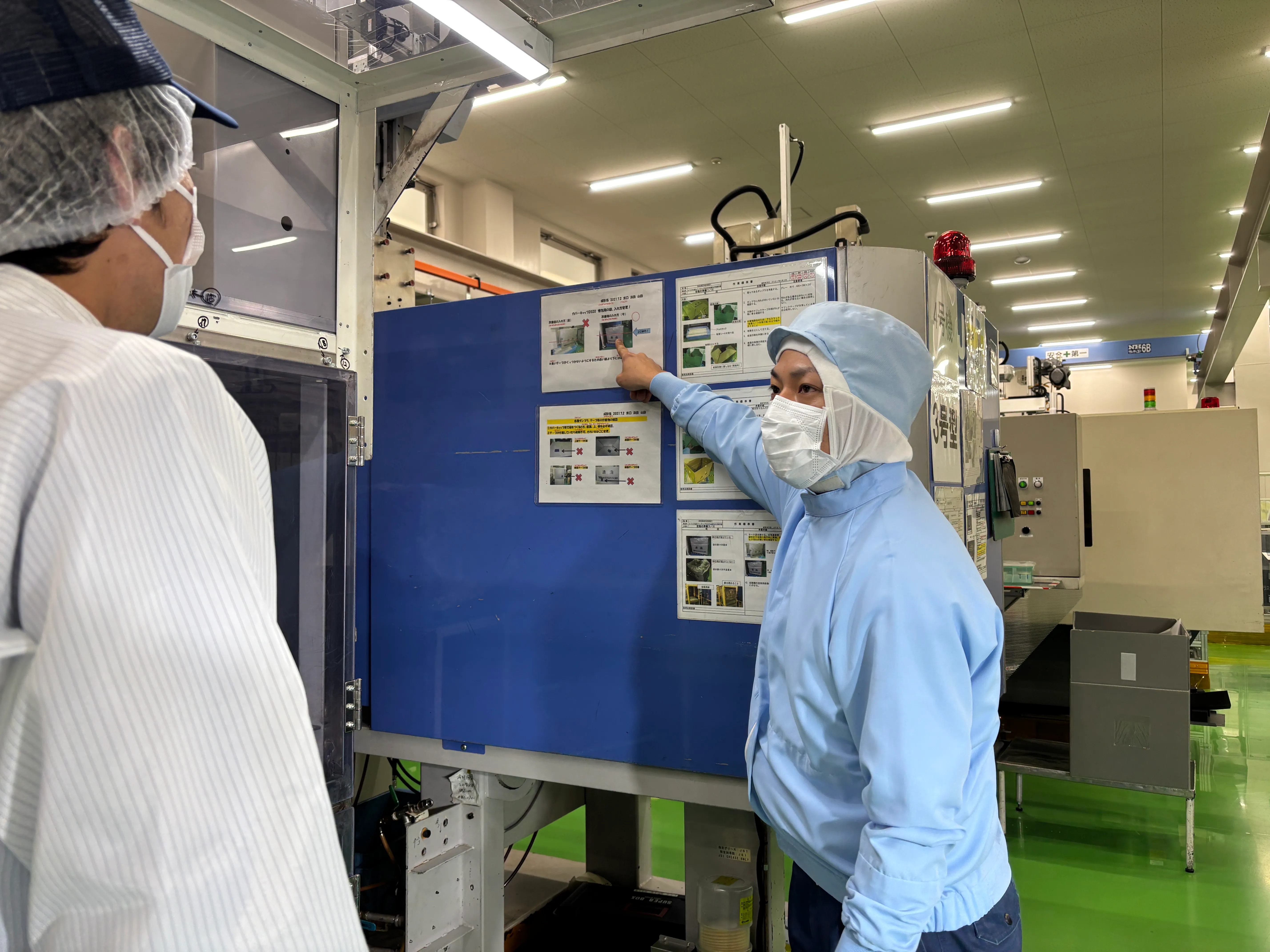 工場のパネルに掲示された手順を確認している様子